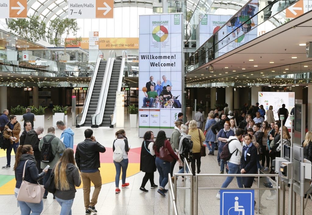 Blick auf den großen, hellen Eingangsbereich der Messe mit einem "WIllkommen"-Banner.