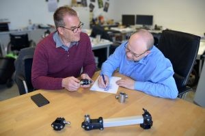 Andreas Neitzel und Eduard Wiebe tüfteln an einem runden Tisch in ihrem Büro an der Anhängerkupplung.