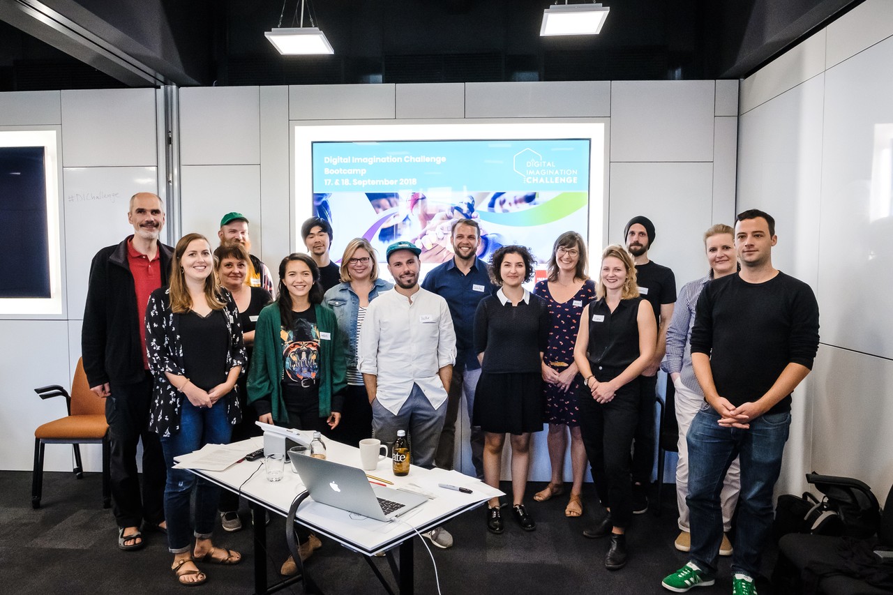 Gruppenfoto vor einer Leindwand: Die Finalisten und Organisatoren der Challenge.
