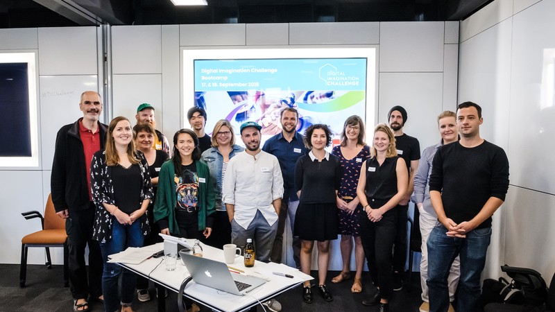 Gruppenfoto vor einer Leindwand: Die Finalisten und Organisatoren der Challenge.
