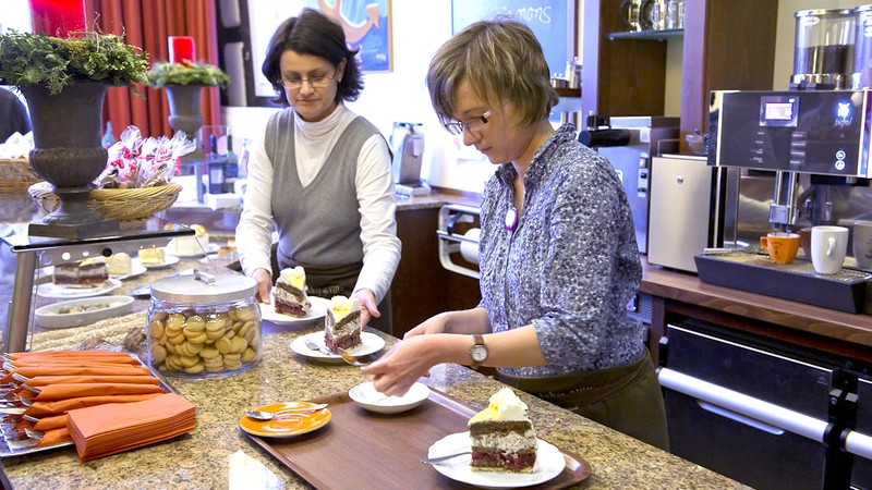 Ann-Sophie Bathe beim Anrichten von Kuchenstücken hinter der Theke des Cafés Anker Villa.
