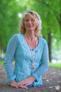 Silke Naun-Bates steht auf einer Allee und lächelt in die Kamera.