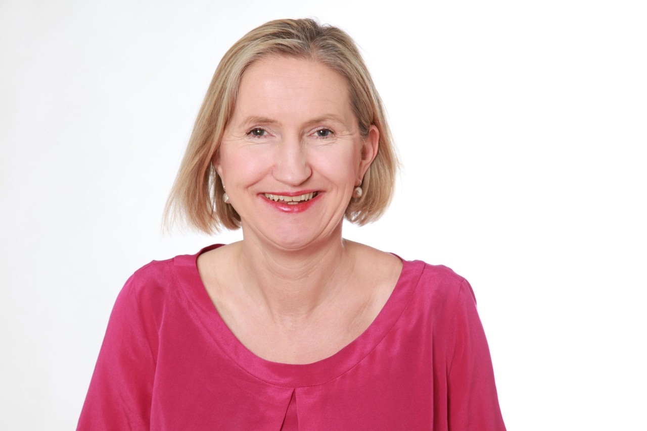 Dörte Maack trägt einen pinken Pulli und lacht in die Kamera.