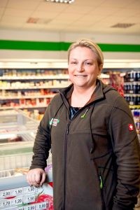 Olga Barthel, die Marktleiterin im Supermarkt des Servicehauses Stemwede, vor einer der Kühltruhen im Laden.