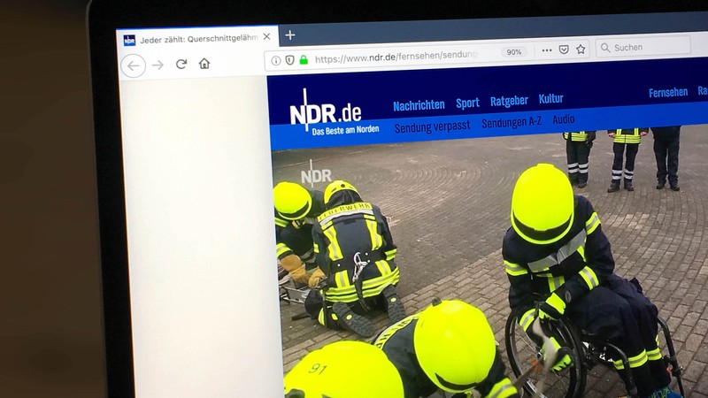 Foto der NDR-Seite, auf der der Video-Beitrag zu sehen ist. Das Standbild zeigt Finn-Niklas Gerken in Feuerwehrkleidung in seinem Rollstuhl, umgeben von seinem Team.