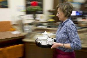 Ann-Sophie Bathe läuft mit einem Tablett voller Geschirr durch das Café Anker-Villa.